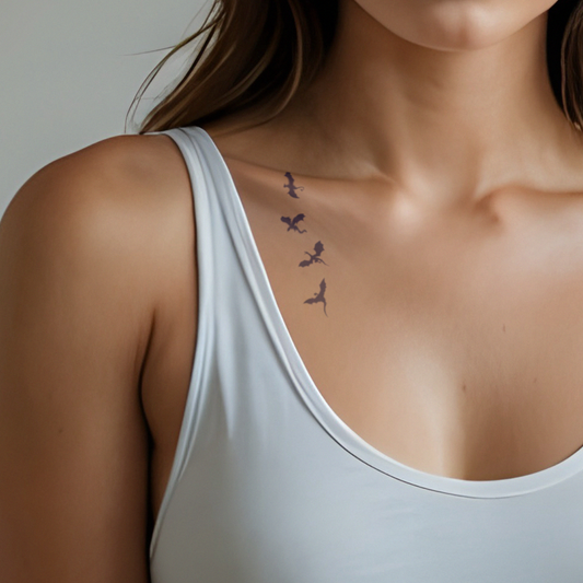 woman wearing a white tank top with a subtle tattoo on her shoulder.
