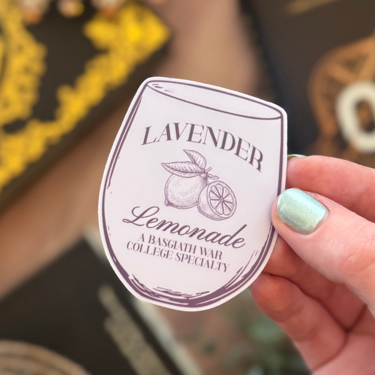 Hand holding a lavender lemonade label with a blurred background