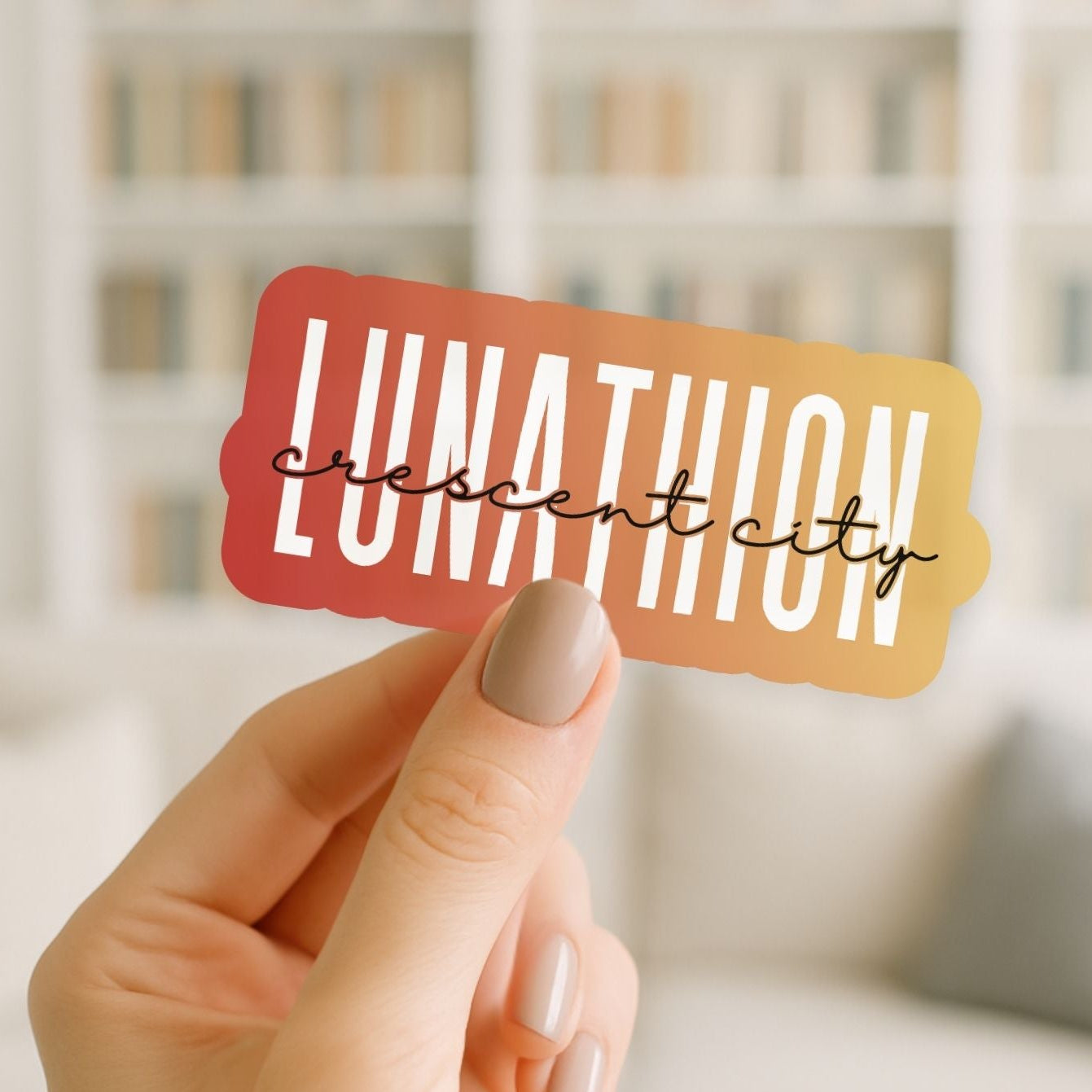 Hand holding a colorful rectangular sticker with 'Lunation Crescent City' text.