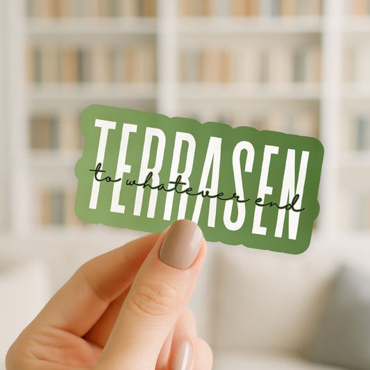 Hand holding a green sticker with 'TERRASEN' text against a blurred background
