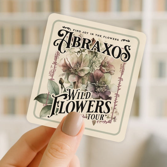 Card with floral design and text held by a hand against a blurred background