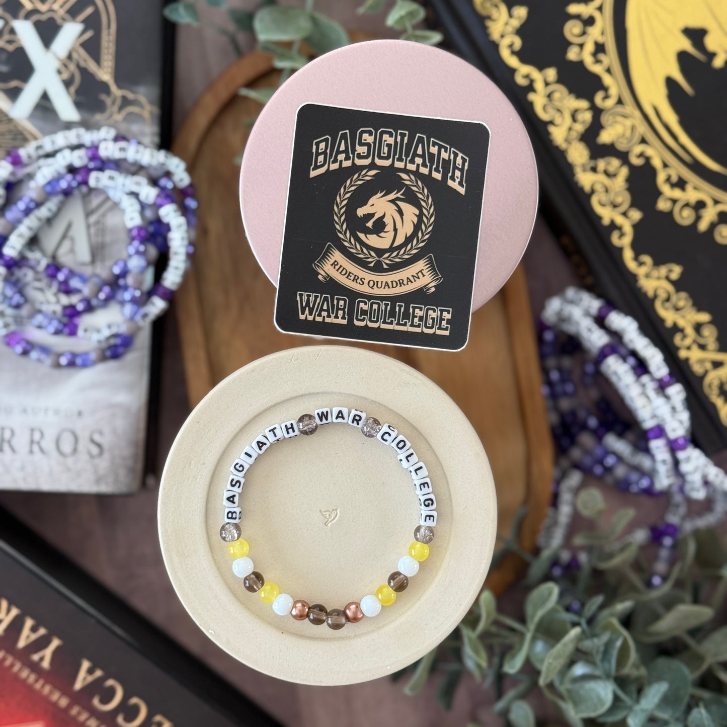 Beaded bracelet with 'BASGLATH' label on a wooden stand, surrounded by decorative items.