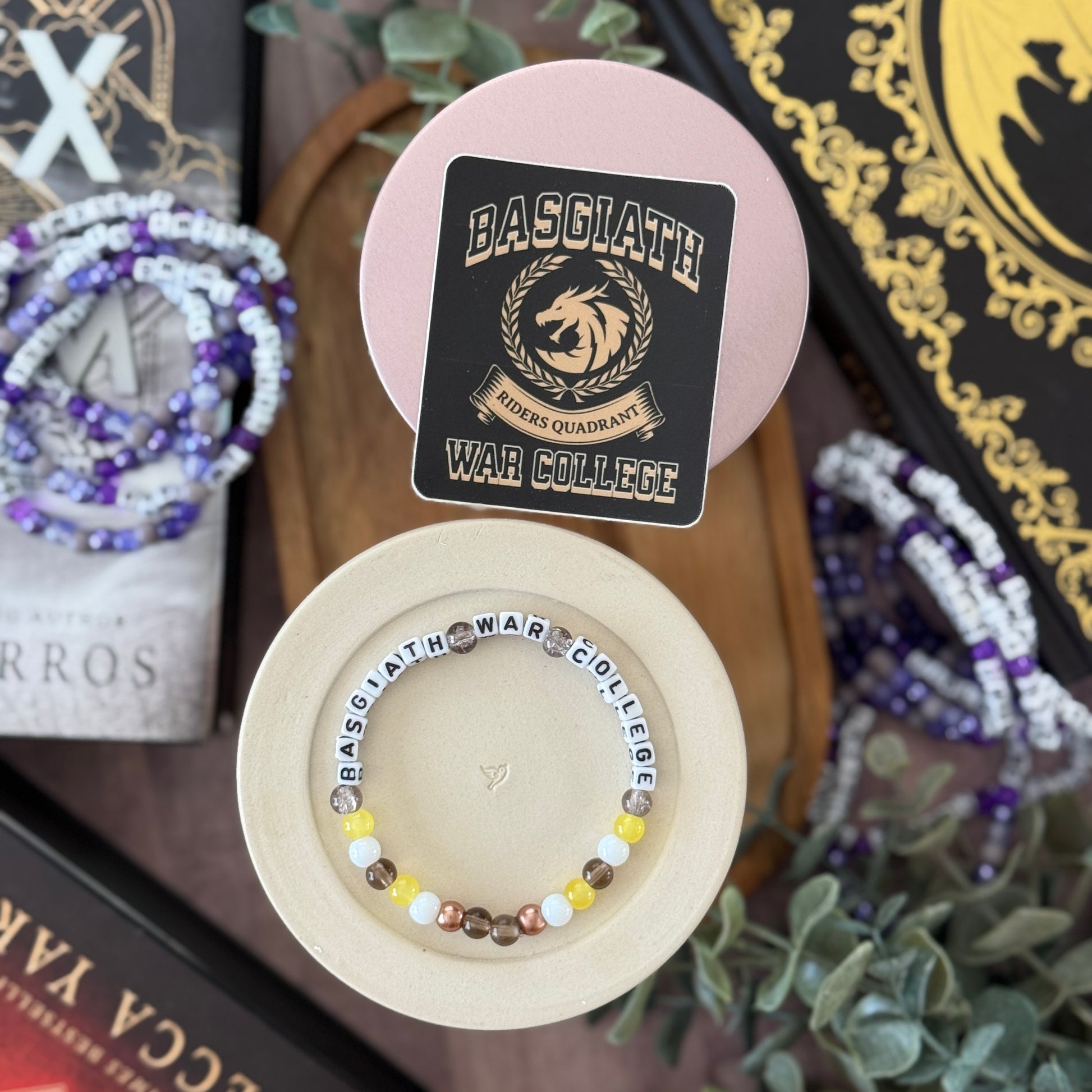 Beaded bracelet with 'BASGLATH' label on a wooden stand, surrounded by decorative items.