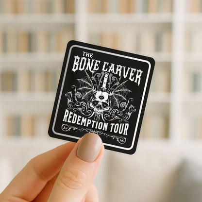 Sticker with 'The Bone Carver Redemption Tour' design held by a hand against a blurred background