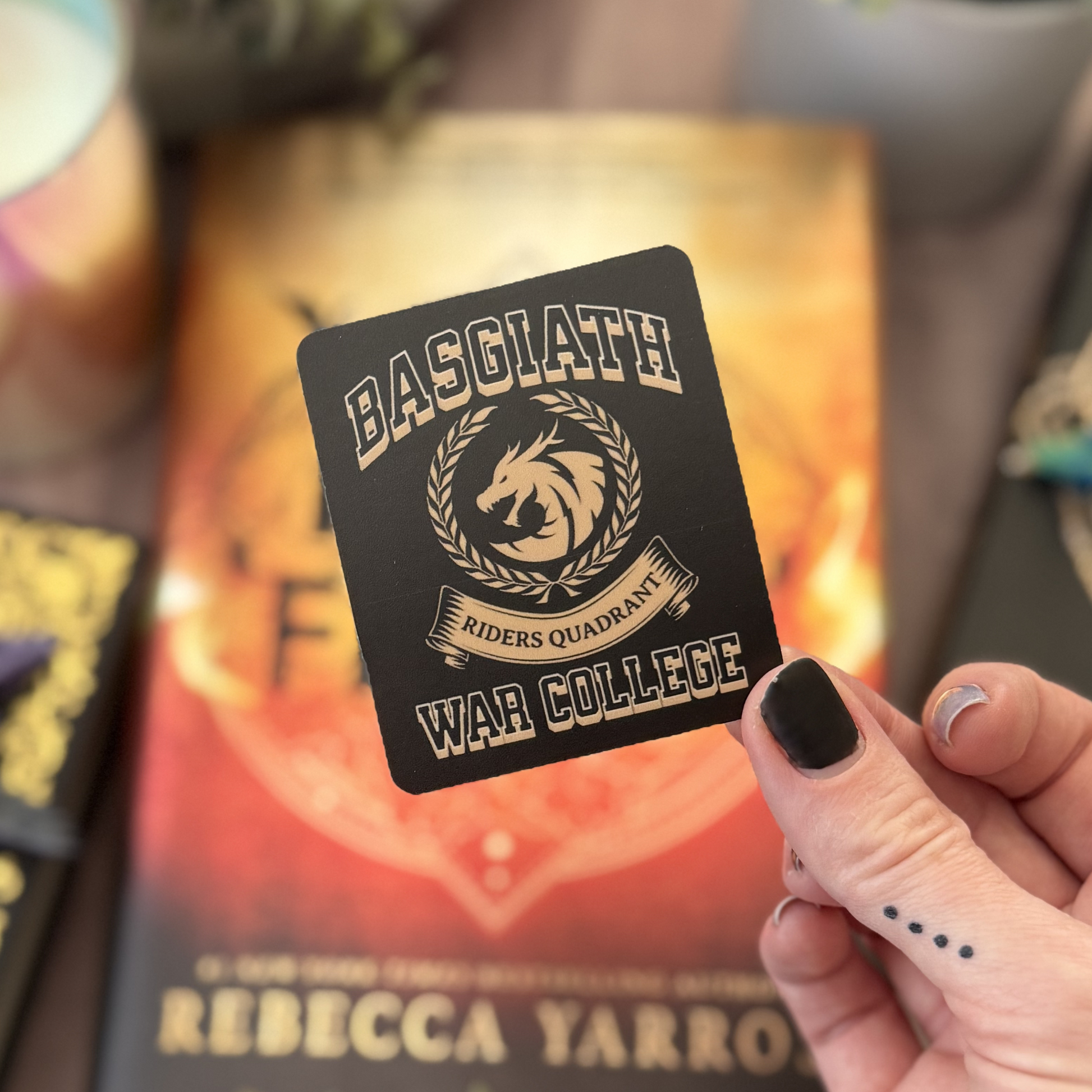 Hand holding a card with 'Basglathe Riders Quadrant War College' design.