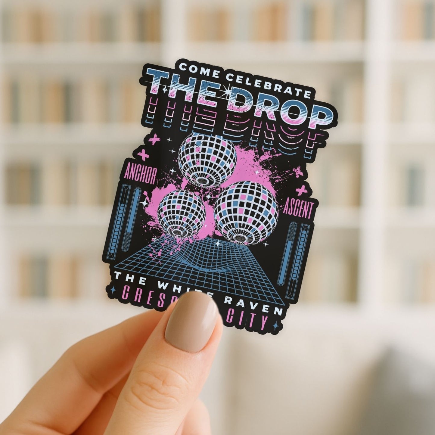 Sticker with disco ball design held by a hand against a blurred background