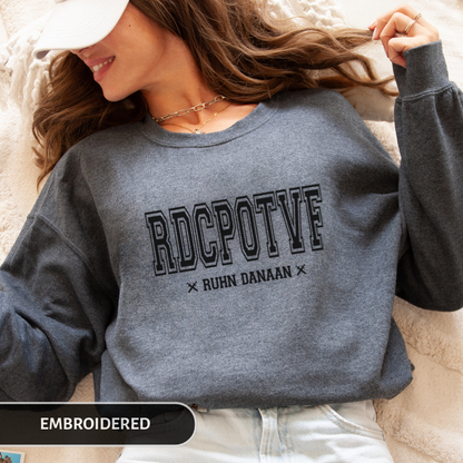 Person wearing a gray sweatshirt with 'RDCPOTF' text, lying on a soft surface.