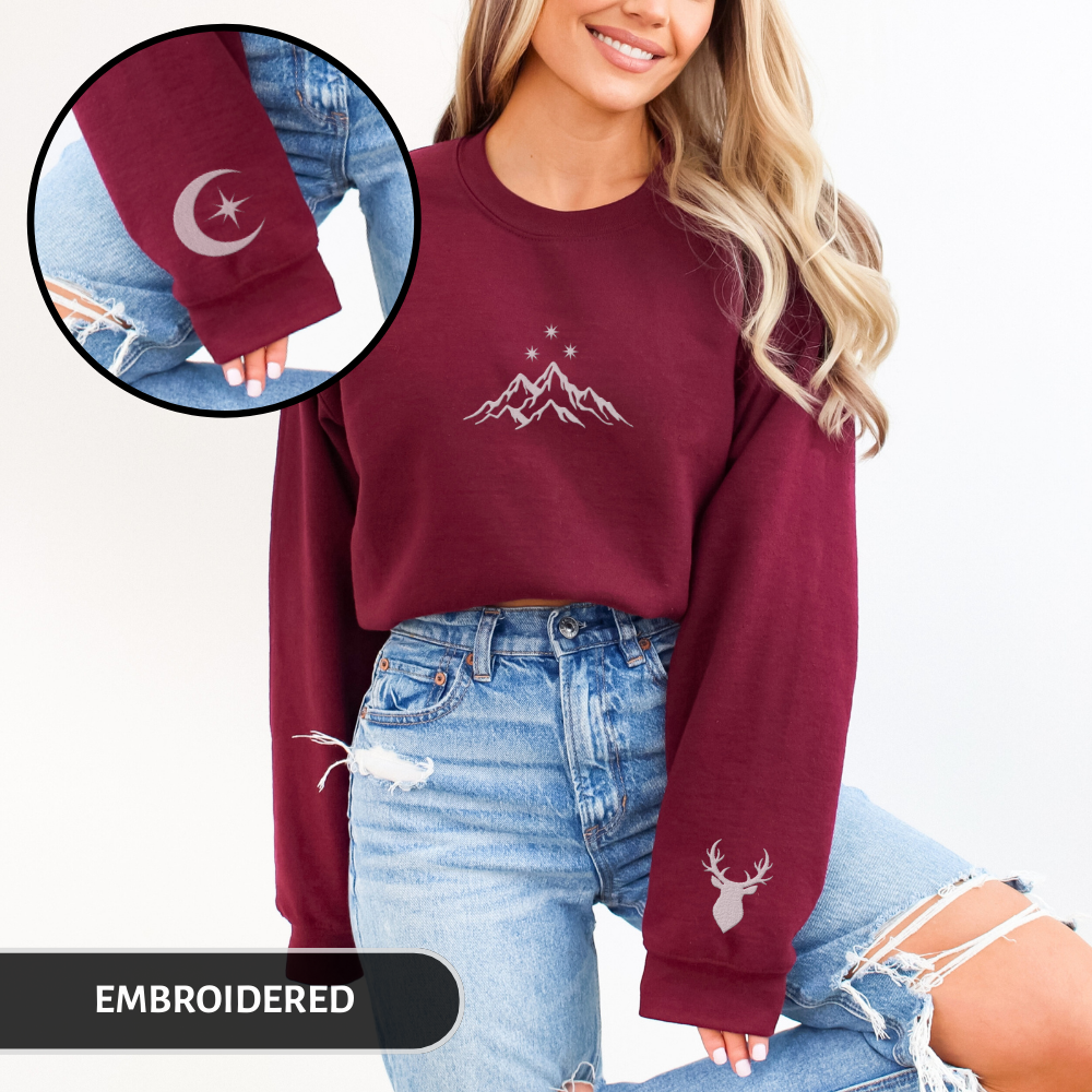 Woman wearing a maroon sweatshirt with embroidered designs
